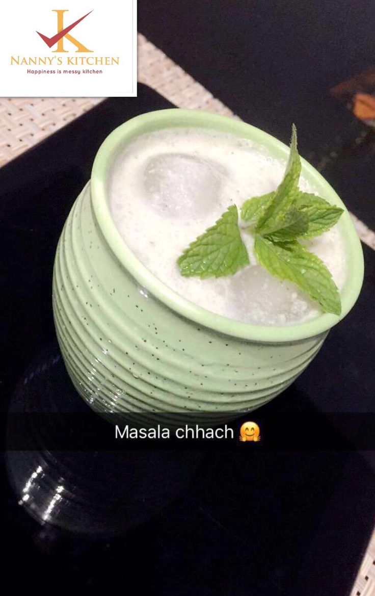 a green bowl filled with ice and mint on top of a counter