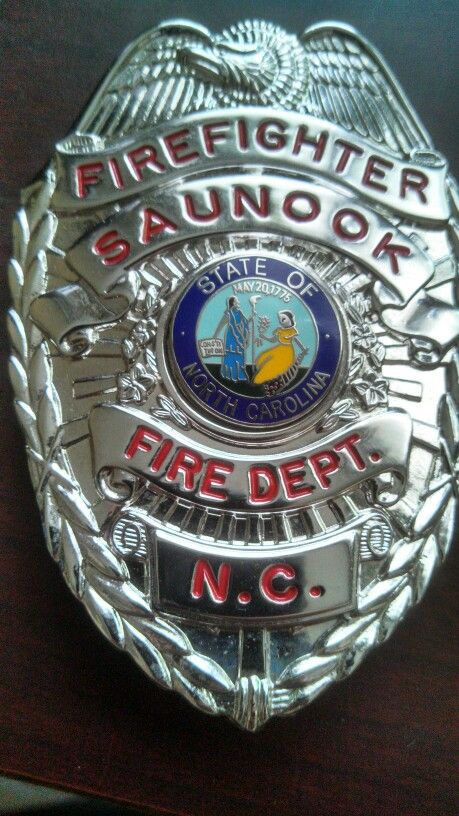 a fire department badge sitting on top of a wooden table