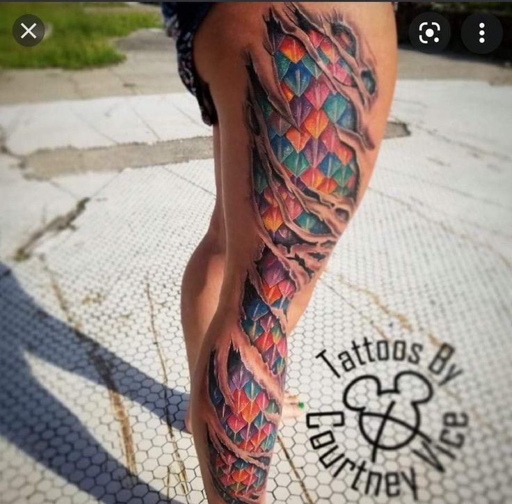 a woman's leg with colorful tattoos on it