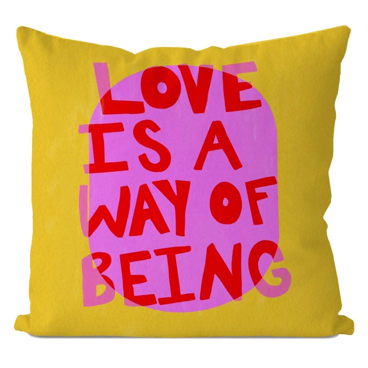 a pink and yellow pillow with the words love is a way of being printed on it