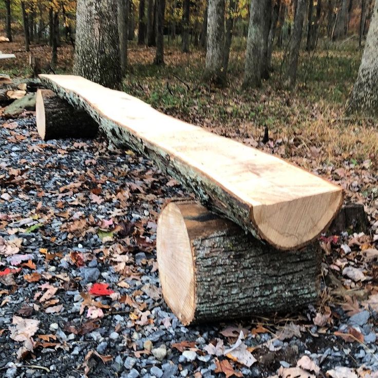 a wooden bench sitting on top of a pile of leaves