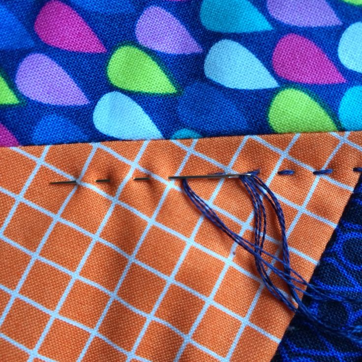 an orange and blue tie laying on top of each other next to a pair of scissors