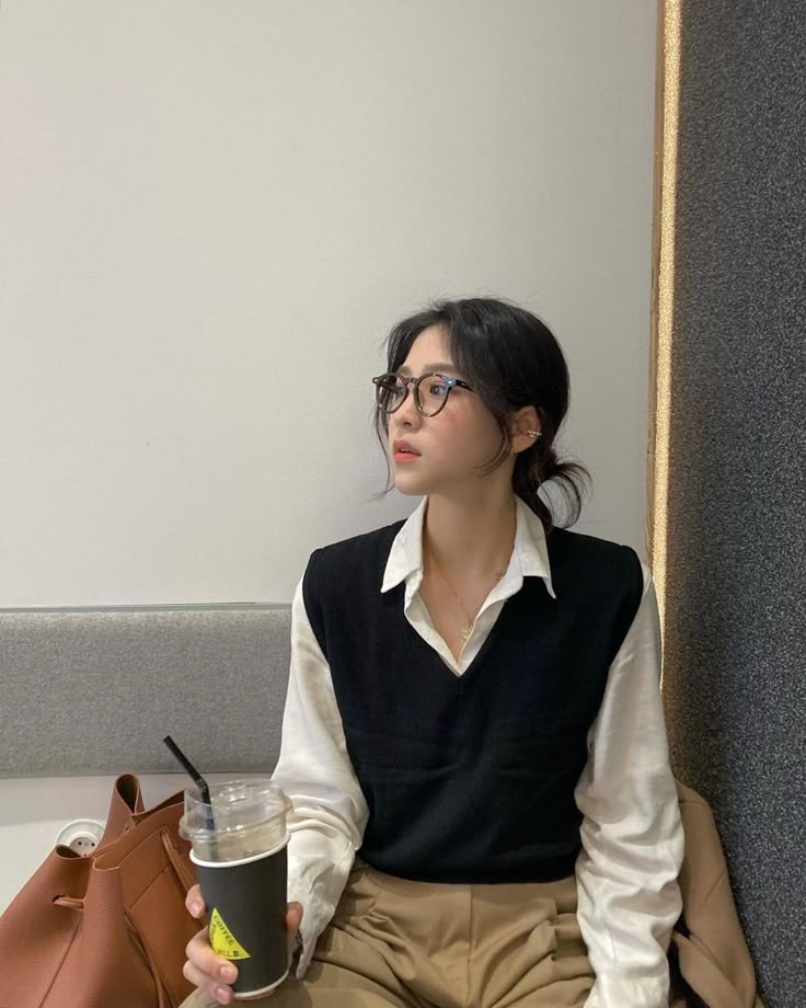 a woman sitting on the floor holding a coffee cup