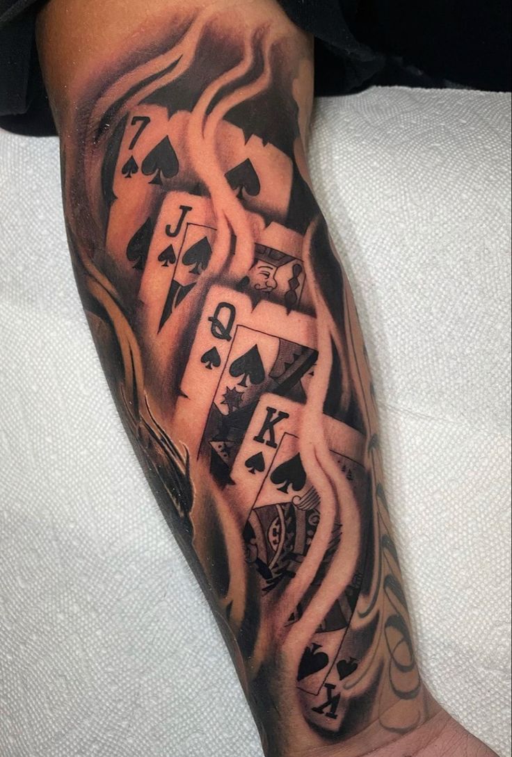 a man's arm with playing cards on it