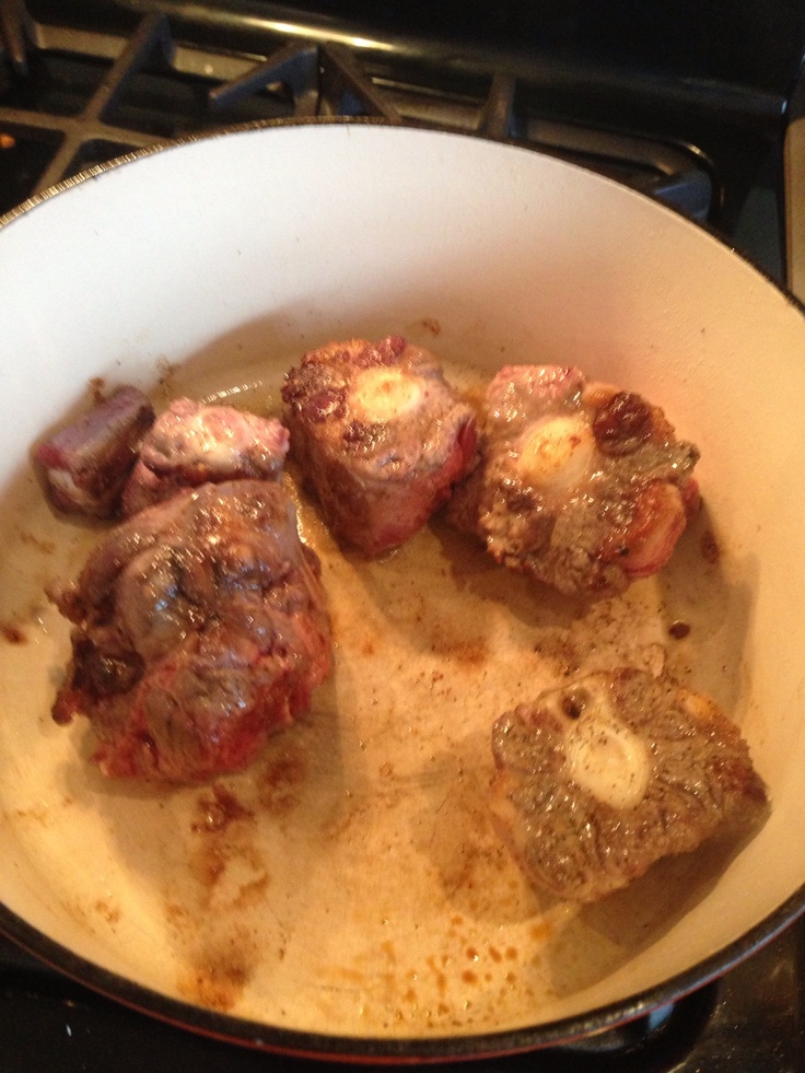 some meat is cooking in a pot on the stove