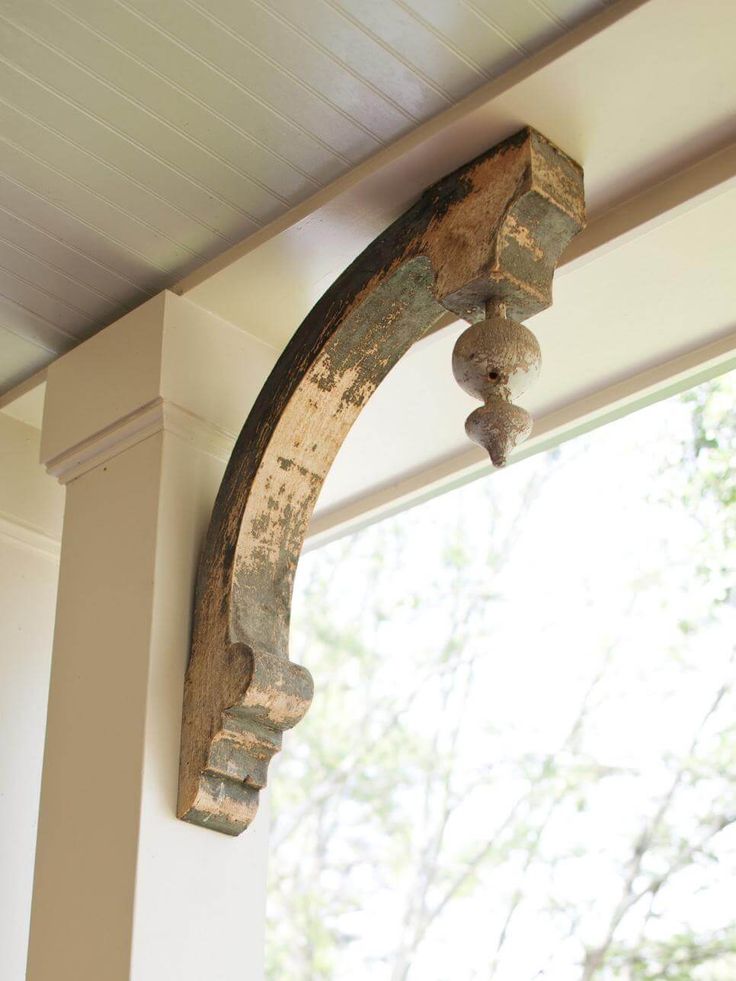 an old wooden arch hanging on the side of a house