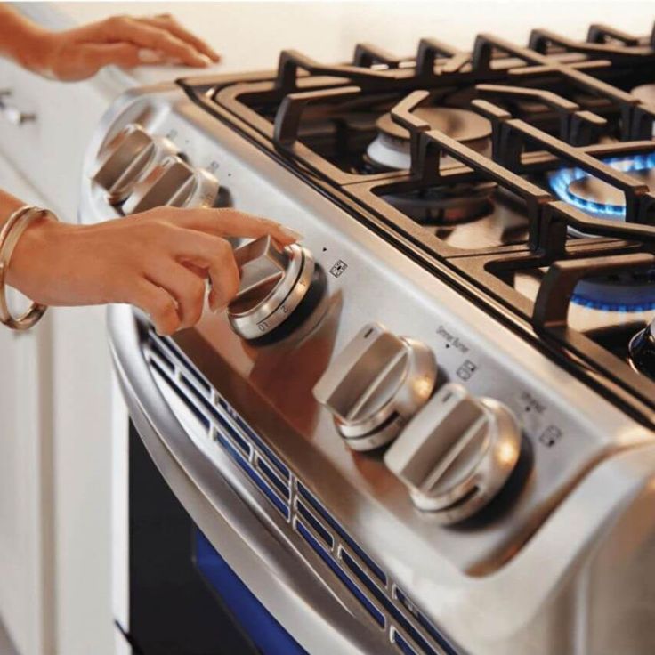 a woman is pulling the knobs on her stove