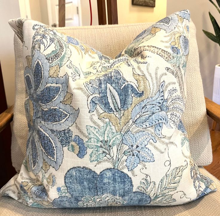 a blue and white pillow sitting on top of a chair