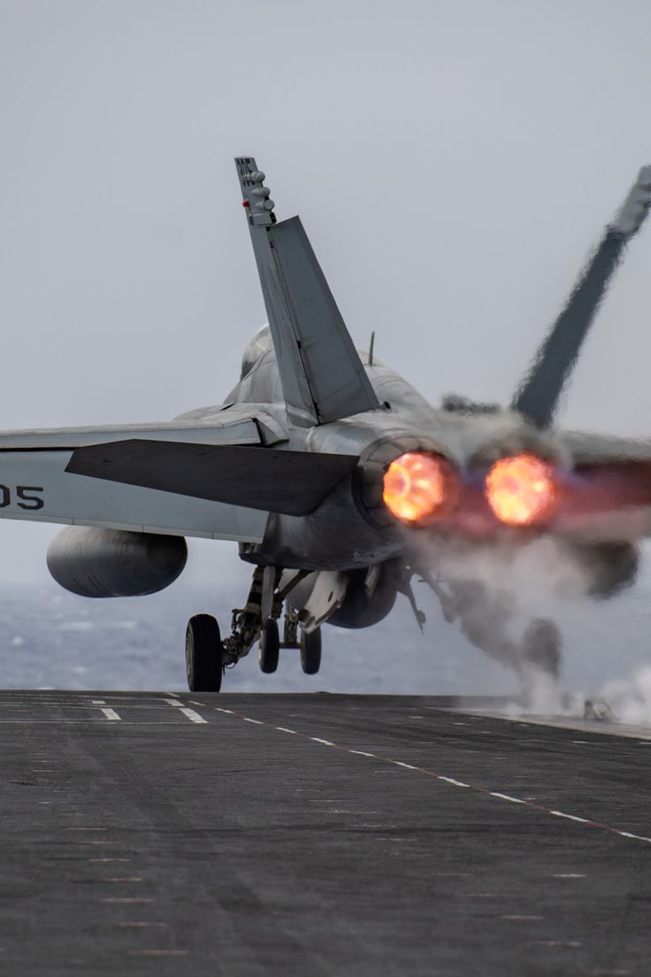 a fighter jet taking off from an aircraft carrier