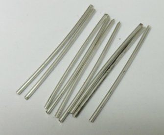 four metal straws on a white surface