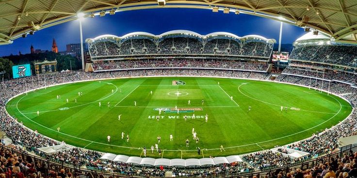 a stadium filled with lots of people watching a soccer game in the middle of it