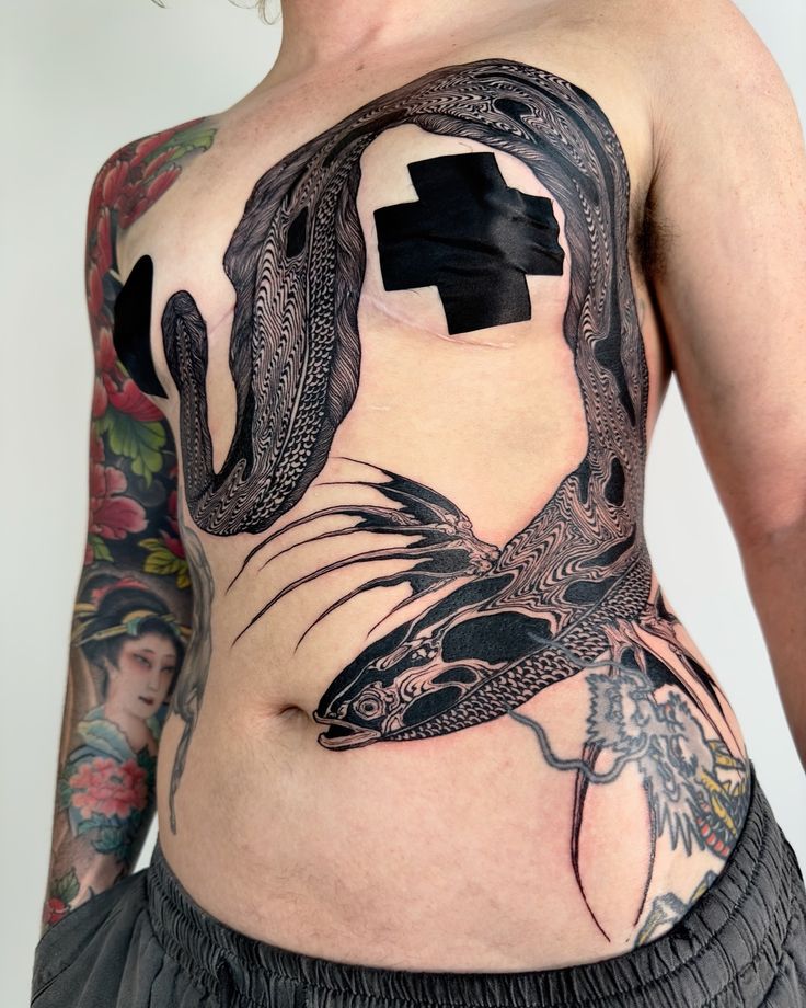 a woman with tattoos on her stomach has a cross in the shape of a dragon