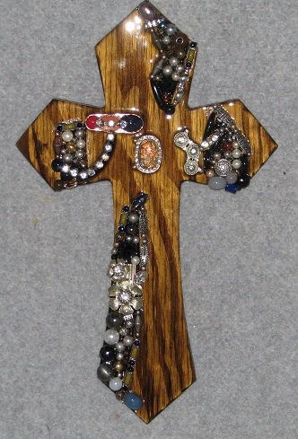 a cross made out of wood with beads and other items on it's side