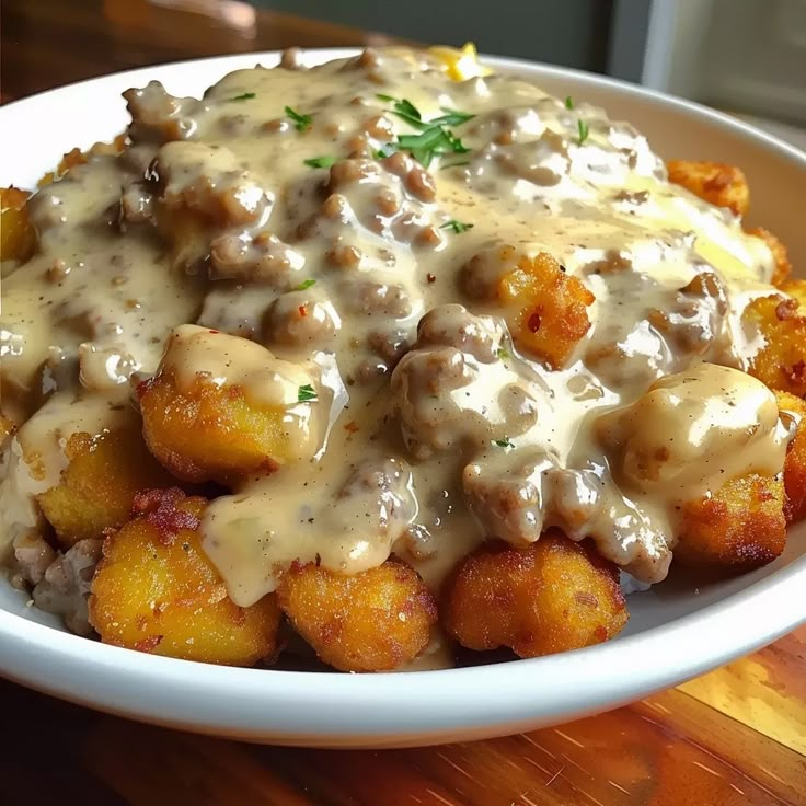 a white plate topped with tater tots covered in gravy