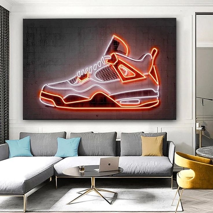 a living room with a couch, coffee table and neon shoe artwork on the wall