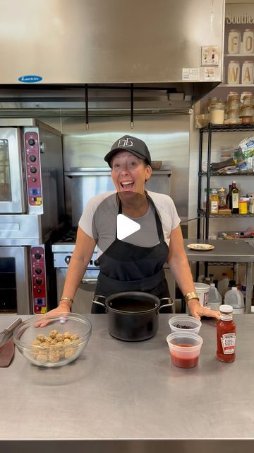 a woman standing in front of a counter filled with food