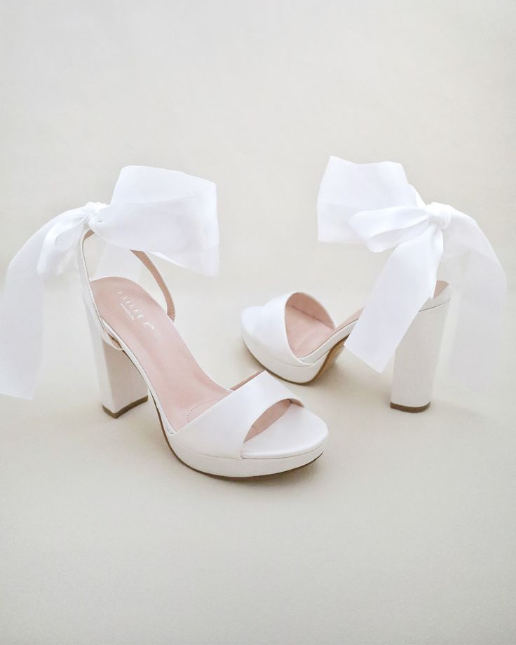 Satin block heel sandal with wrapped satin/sheer ankle tie. Elegance and classic inspired wear for your special day. Perfect for brides, bridesmaids, prom night, date night, and definitely a highlight on every special occasions.DETAILS:HEELS: 4 inchesCOLORS AVAILABLE: Ivory, White and Light BlueUPPER: Synthetic upper and liningMATERIALS: Manmade outsoleORIGIN: ImportedSTYLE NAME: ATHENA Tie Up Shoes, Pretty White Heels, Bridal Shoes With Bows, White Ankle Wrap Heels, Cute Prom Shoes, Graduation Heels College, White Heels With Bow, White Heels With Bow For Events, Summer White Heels With Satin Bow