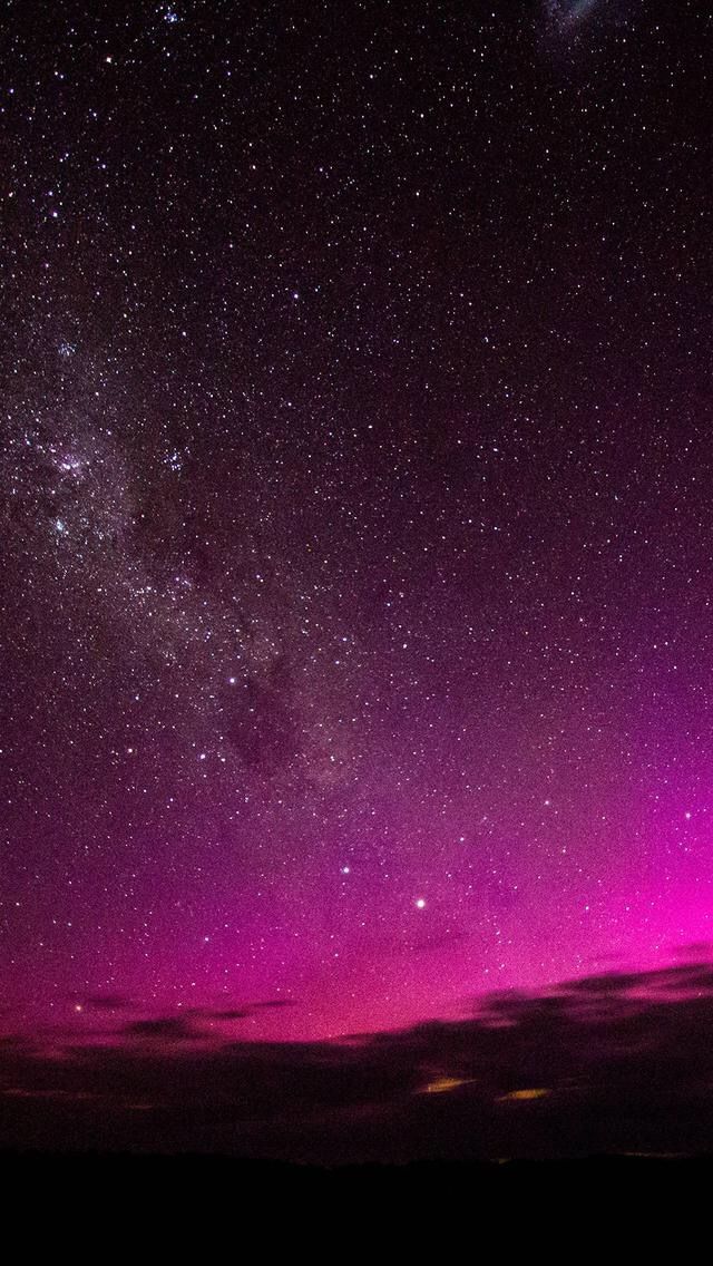 the night sky is filled with stars and purple hues as seen from an airplane