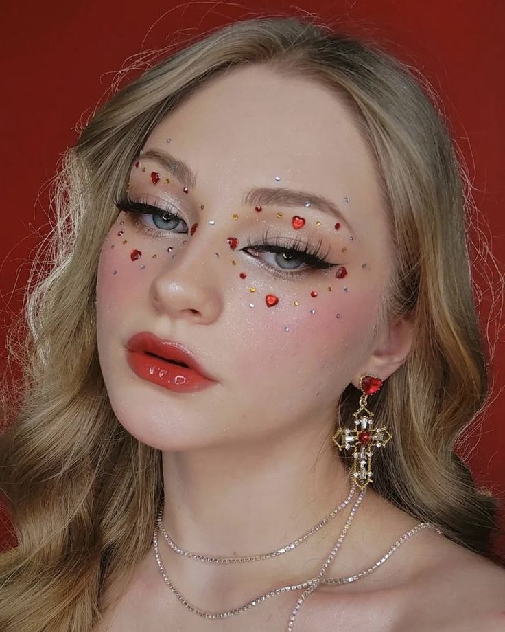 Valentines Makeup With Gems, Heart Tears Makeup, Heart Festival Outfit, Heart Gems On Face, Red Jewels Makeup, Eye Makeup With Hearts, Heart Glitter Makeup, Cupid Inspired Makeup, Queen Of Hearts Simple Makeup