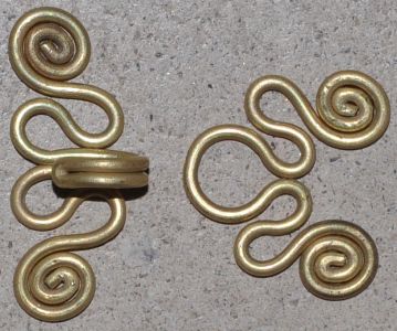 two brass colored metal hooks on the ground