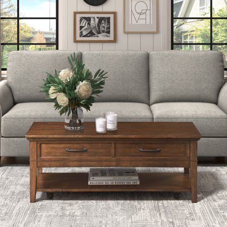 a living room scene with focus on the couch and coffee table in front of the window