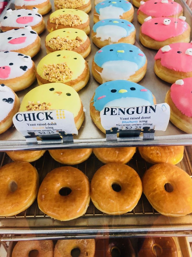 there are many donuts with different designs on them in the display case at the store