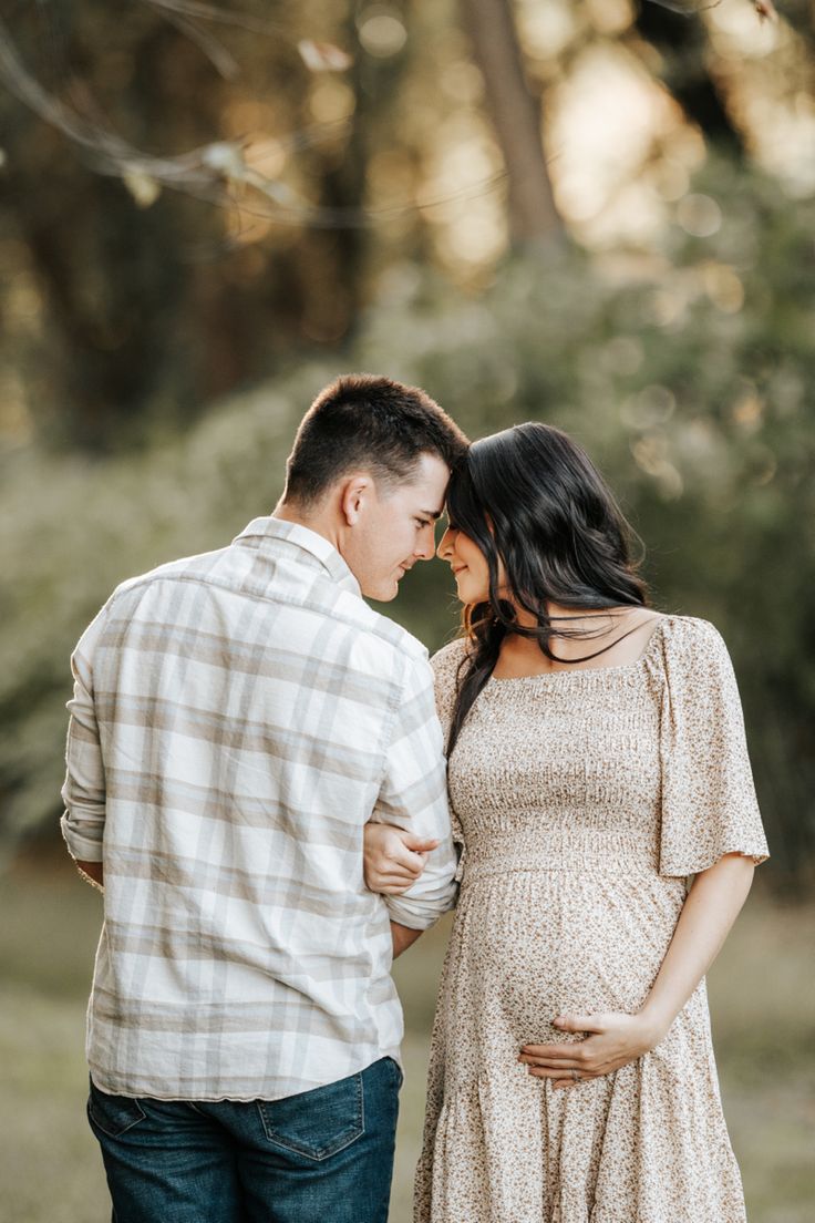 a pregnant couple standing close to each other