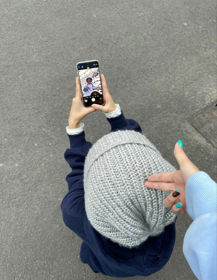 a person holding up a cell phone to take a photo with their head in the air