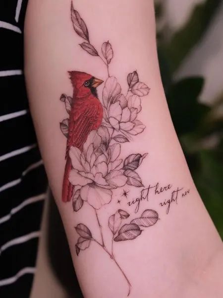 a red bird sitting on top of a branch with leaves and flowers around it's neck