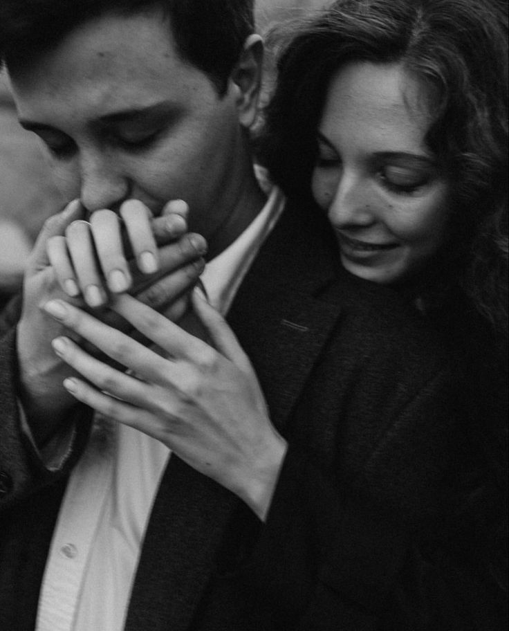 black and white photograph of a man and woman holding each other's hands together