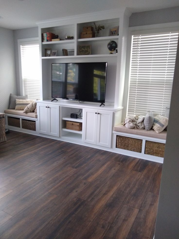 a living room filled with furniture and a flat screen tv on top of a wooden floor