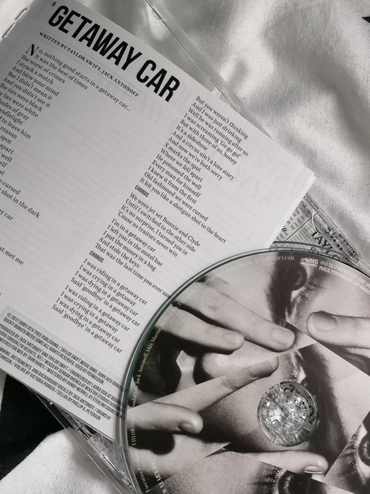 a cd sitting on top of a bed next to a white sheet with the words getaway car written on it