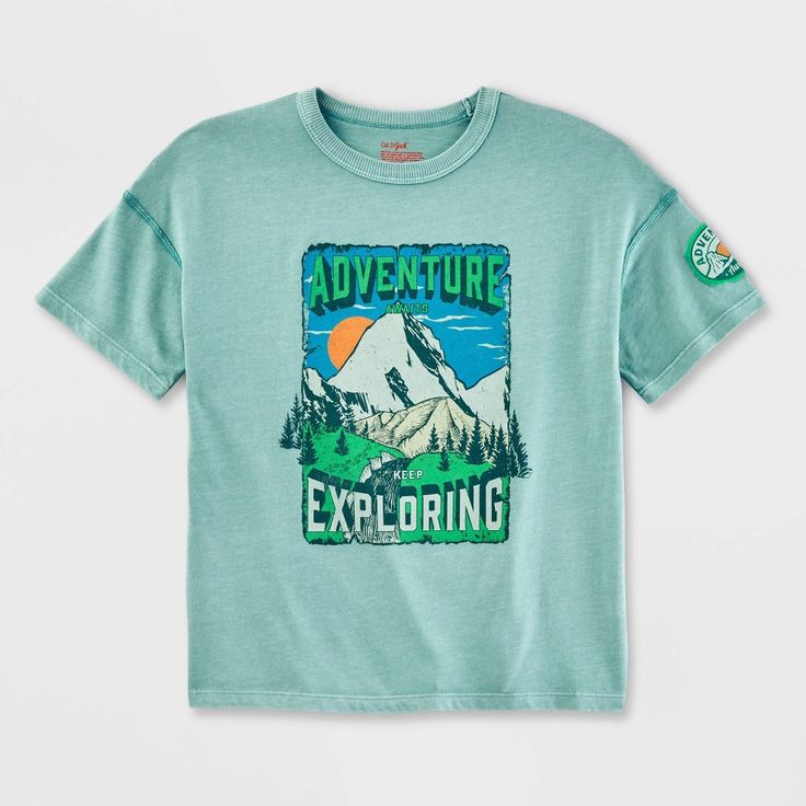 They'll be ready to explore the outdoors in comfy, cool style by wearing the Adaptive Short-Sleeve Adventure Knit Top from Cat & Jack™. Specially designed for sensory needs, this short-sleeve T-shirt features flat seams and no tags to eliminate abrasion against the skin. Seams are intentionally chosen to withstand high level activity without irritating the skin. Garment care and size information is provided through heat seal labels, not itchy tags. It comes with a pullover style that makes it ea Short Sleeve Screen Print Adventure Shirt, Green Graphic Print T-shirt For Outdoor, Short Sleeve Logo Print T-shirt For Outdoors, Outdoor Short Sleeve T-shirt With Front Print, Green Graphic Print T-shirt For Hiking, Ocean Green, Adaptive Clothing, Sensory Friendly, Flannel Tops