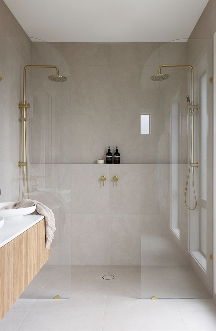 a bathroom with two sinks and a large shower in the corner, along with a walk - in shower