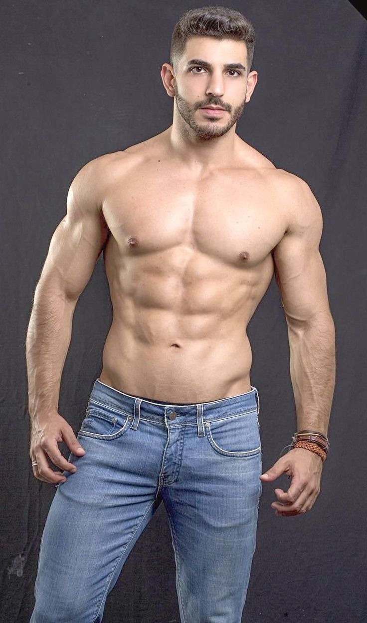 a shirtless man posing for the camera with his hands in his pockets and no shirt on