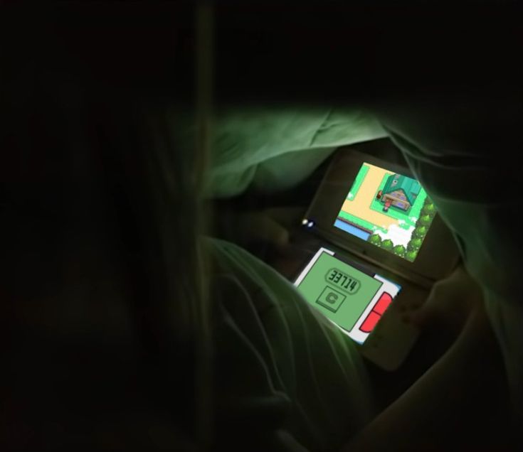 a cell phone sitting on top of a bed next to a person in the dark