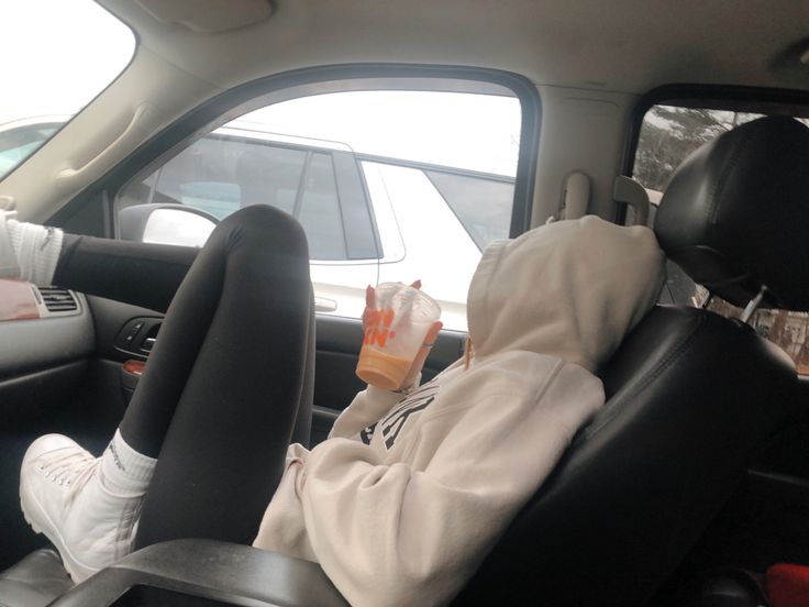 a person is sitting in the back seat of a car with their feet propped up