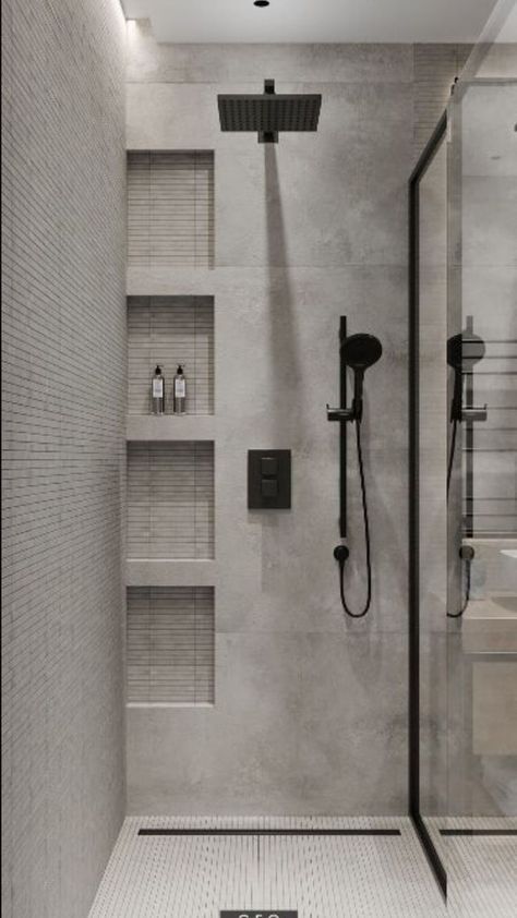 a walk in shower sitting next to a white tiled wall and floor with shelves on either side