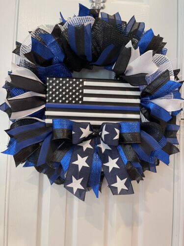 a patriotic wreath with an american flag and stars on it hanging from the front door