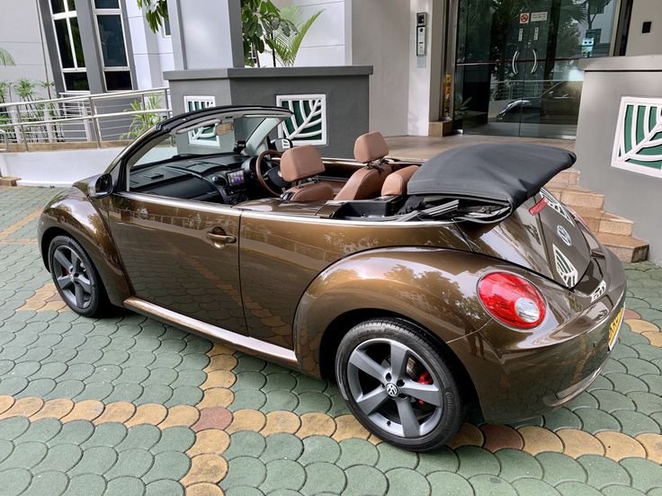 a brown convertible car parked in front of a building