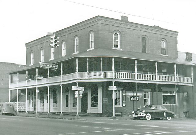 an old black and white photo of a street corner