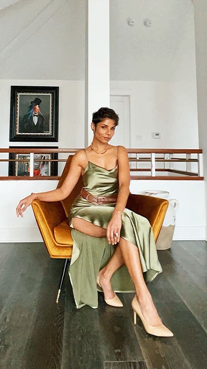 a woman in a green dress sitting on a chair