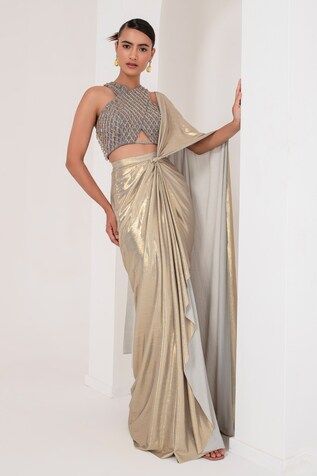 Grey and gold toned pre-draped saree crafted in metallic georgette. Paired with a sleeveless halter neck blouse with tonal crystal tassel and cutdana embellishments. - Aza Fashions Gold Pre-draped Saree For Diwali Reception, Gold Pre-draped Saree For Party, Fitted Gold Pre-draped Saree For Festive Occasions, Gold Pre-draped Saree For Reception And Festive Occasions, Glamorous Silk Draped Saree, Pre-draped Blouse Piece With Zari Work For Reception, Gold Pre-draped Saree With Zari Work, Pre-draped Saree With Zari Work For Festive Occasions, Gold Pre-draped Saree For Festive Occasions