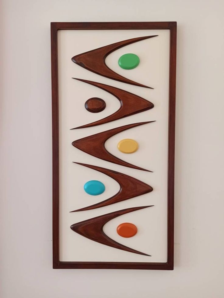 an art piece hanging on the side of a wall with three different colored balls in it