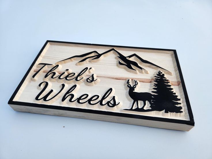 there is a wooden sign that says, three's wheels with a deer on it