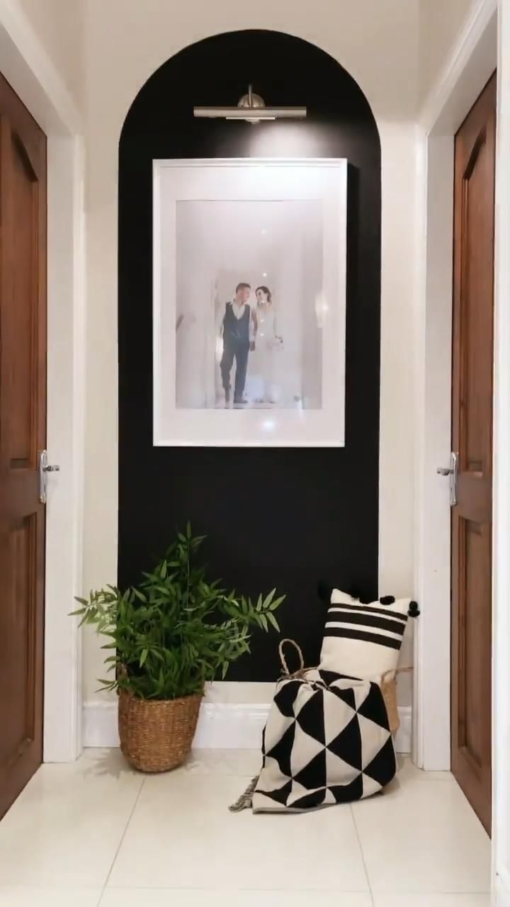 a black and white photo hanging on the wall next to a plant in a pot