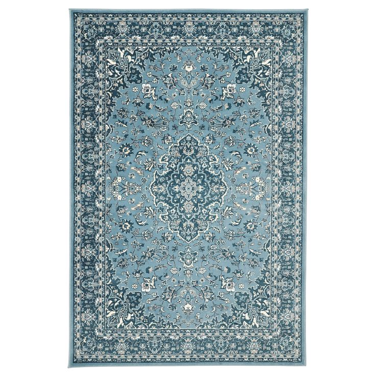 a blue rug with an ornate design on the center and bottom, in various colors