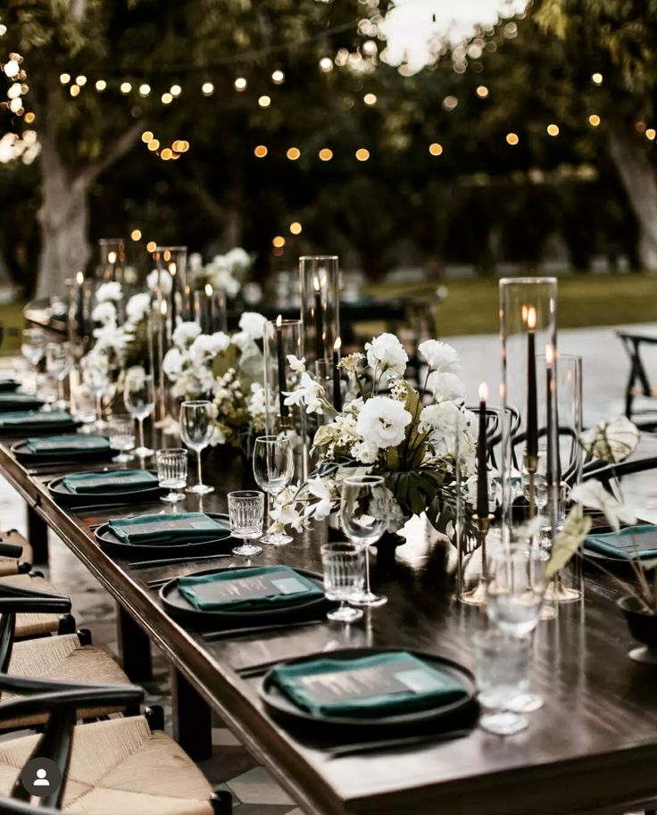 a long table is set with place settings and candles