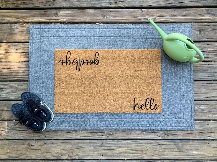 a door mat with the words shg and ni written on it next to a pair of shoes