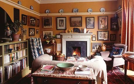 a living room filled with lots of furniture and pictures on the wall above it's fireplace